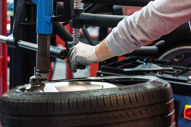 Auto mechanic repairing tire
